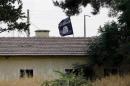 An Islamic State flag flies over the customs office of Syria's Jarablus border gate as it is pictured from the Turkish town of Karkamis