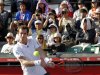 Andy Murray of Britain returns a shot to Stanislas Wawrinka of Switzerland in front of spectators shielding from the sun during their men's singles quarter-finals match at the Japan Open tennis championships in Tokyo