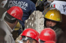 An emergency responder carries a piece of concrete as emergency workers and firefighter dig for survivor at the site on an explosion at an adjacent building to the executive tower of Mexico's state-owned oil company PEMEX, in Mexico City, Thursday Jan. 31, 2013. The explosion killed more than 10 people and injured some 80 as it heavily damaged three floors of the building, sending hundreds into the streets and a large plume of smoke over the skyline. (AP Photo/Eduardo Verdugo)