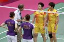 An official speaks to players from China and South Korea during their women's doubles badminton match during the London 2012 Olympic Games at the Wembley Arena