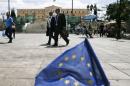 People make their way past a small EU flag on Constitution (Syntagma) Square in Athens