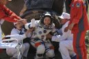 In this photo released by China's Xinhua news agency, China's first female astronaut Liu Yang waves as she comes out of the re-entry capsule of Shenzhou-9 spacecraft in Siziwang Banner of north China's Inner Mongolia Autonomous Region Friday, June 29, 2012. Liu and two other crew members emerged smiling from the capsule that returned safely to earth Friday from a 13-day mission to an orbiting module that is a prototype for a future space station. (AP Photo/Xinhua, Wang Jianmin) NO SALES