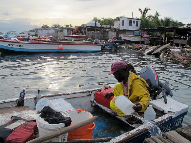 Fisherman Daniel Edwards bails his small wooden skiff out in Port Royal, a fishing village just outside of Kingston, Jamaica, Sunday Aug. 5, 2012. Tropical Storm Ernesto is pushing for a brush with Jamaica on Sunday. (AP photo/David McFadden)