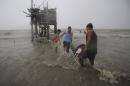 Residents carry their belongings towards their house on stilts as strong winds and rains caused by Typhoon Koppu hits the coastal town of Navotas, north of Manila, Philippines on Sunday, Oct. 18, 2015. Slow-moving Typhoon Koppu blew ashore with fierce wind in the northeastern Philippines early Sunday, toppling trees and knocking out power and communications. (AP Photo/Aaron Favila)