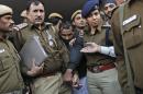 Policemen escort driver Yadav who is accused of a rape outside a court in New Delhi
