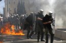 A petrol bomb, thrown by protesters, explodes near riot police during a violent protest in Athens' Syntagma square