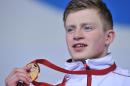 Gold medallist England's Adam Peaty poses on the podium during the Men's 100m Breaststroke medal ceremony at the Tollcross International Swimming Centre during the 2014 Commonwealth Games in Glasgow on July 26, 2014