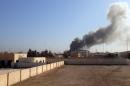 Smoke is billowing after a building is hit by a mortar shell in Ramadi as the Islamic State jihadist group launches a coordinated attack on government-held areas of the Iraqi city, on March 11, 2015