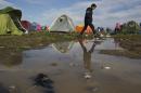 A boy walks past tents after a rainfall while waiting to be allowed to cross the border into Macedonia in the northern Greek border station of Idomeni, Friday, March 4, 2016. More than 10,000 mostly Syrian and Iraqi refugees were stuck at the country's Idomeni border as Greek officials said that nearly 32,000 migrants were stranded in the country after drastically reduce of number of transiting migrants. (AP Photo/Petros Giannakouris)