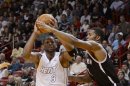 Miami Heat's Dwyane Wade is defended by Brooklyn Nets's Joe Johnson during the first half of their NBA basketball game in Miami