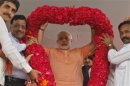 Gujarat's CM Modi receives a rose garland by his supporters during an election campaign rally ahead of the state assembly elections at Fagvel village in Gujarat