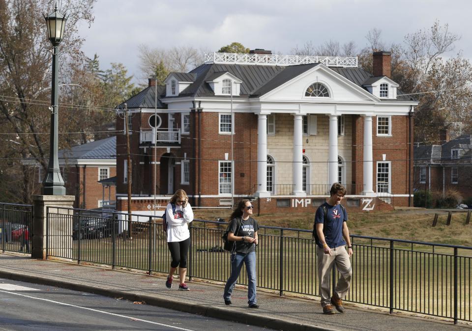 University of Virginia students walk to campus past the Phi Kappa Psi fraternity house at the University of Virginia in Charlottesville, Va., Monday, ...