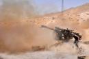 A Syrian soldier fires artillery shells towards Islamic State (IS) group jihadists during clashes near the northeastern city of Palmyra, on May 17, 2015