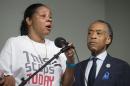 Esaw Garner, wife of Eric Garner, left, speaks alongside the Rev. Al Sharpton during a rally at the National Action Network headquarters, Saturday, July 26, 2014, in New York. Eric Garner, 43, died on Thursday, July 18, during an arrest in Staten Island, when a plain-clothes police officer placed him in what appeared be a choke hold while several others brought him to the ground and struggled to place him in handcuffs. (AP Photo/John Minchillo)