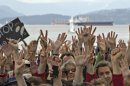 Protestors gathered on Kitsilano Beach hold up their hands to show their opposition to the Northern Gateway Pipeline and the use of oil tankers in local waters in Vancouver
