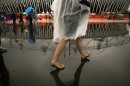 Visitors walk during raining at the Olympic Park during the 2012 Summer Olympics, Sunday, July 29, 2012, in London. (AP Photo/Emilio Morenatti)