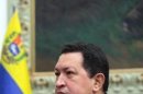 Venezuala's President Hugo Chavez holds a crucifix in Caracas on December, 8, 2012