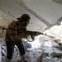 A Free Syrian Army fighter holds his rifle as he walks through an apartment destroyed by a tank shell during clashes with Syrian Army soldiers in the Salah al- Din neighbourhood in central Aleppo