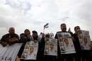 Palestinian protesters hold placards during a demonstration in support of hunger-striking Palestinian prisoner al-Issawi, outside Kaplan hospital near Tel Aviv