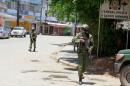 Armed policemen walk outside the central police station after an attack, in the coastal city of Mombasa