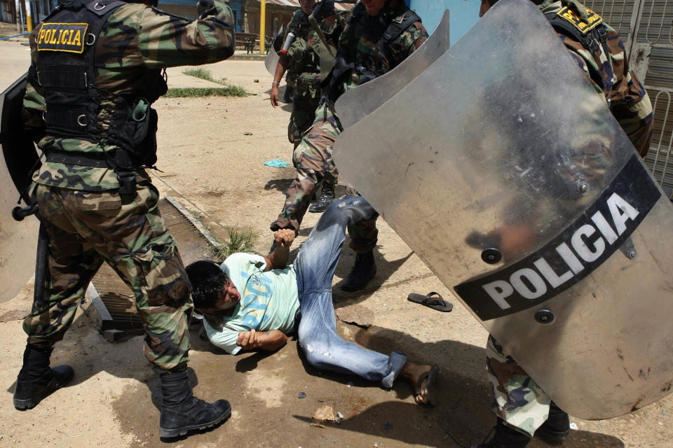 FILE -  In this March 14, 2012 file photo, a miner is roughed up by riot police during clashes in Puerto Maldonado, Peru. Civilian deaths are disturbingly frequent when protesters in provincial Peru confront police. Peru's crowd control tactics are unmatched in lethality according to the independent National Coordinator for Human Rights watchdog. (AP Photo/Miguel Vizcarra, File)