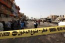 Residents gather at the site a day after a triple bomb attack in Baghdad