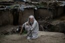 Pakistani Wazeer Khan, 87, sits on a roadside near his home, on the outskirts of Islamabad, Pakistan, Monday, April 1, 2013. Khan and his family fled Pakistan's tribal area of Bajur in 2009, due to fighting between the Taliban and the army, and took refuge in Islamabad. (AP Photo/Muhammed Muheisen)