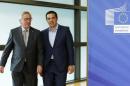 Greek Prime Minister Tsipras walks with European Commission President Juncker ahead of a meeting at the EU Commission headquarters in Brussels