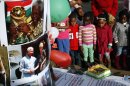 Children stand next to a birthday cake to mark former South African President Nelson Mandela's 95th birthday outside his home in Johannesburg, Thursday, July 18, 2013. South Africa celebrated Nelson Mandela's 95th birthday with acts of charity on Thursday, a milestone capped by news that the former president's health was improving after fears that he was close to death during ongoing hospital treatment. (AP Photo/Jerome Delay)