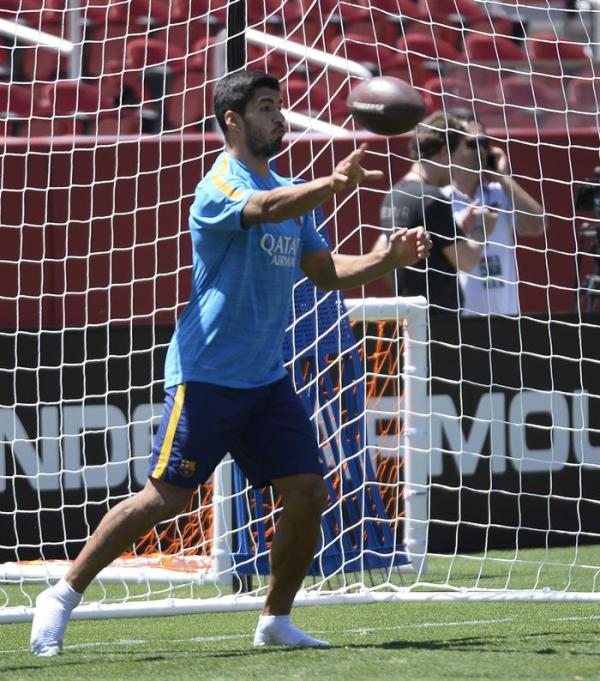 24/07/2015.  FC Barcelona's Luis Suarez passes an American football    football in barcelona july 2015