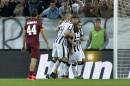 Juventus' forward Carlos Tevez, right, celebrates with his teammates after scoring during a Serie A soccer match between Juventus and Roma at the Juventus stadium, in Turin, Italy, Sunday, Oct. 5, 2014. (AP Photo/Massimo Pinca)