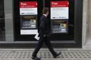 A man walks past automated teller machines outside a HSBC bank in London