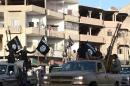An image made available by Jihadist media outlet Welayat Raqa on June 30, 2014, allegedly shows a member of the Islamic state militant group parading in a street in the northern Syrian city of Raqa