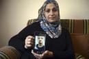 Suha Abu Khdeir, mother of 15-year-old Tariq Abu Khdeir, a U.S. citizen who goes to school in Tampa, Florida, sits in her home and shows a tablet with a photo of Tariq taken in a hospital after he was beaten and arrested by the Israeli police during clashes sparked by the murder Thursday of his cousin Mohammed Abu Khdeir, in Jerusalem, Saturday, July 5, 2014. Israeli police spokeswoman, said that Tariq Abu Khdeir had resisted arrest and attacked police officers. Tariq's father said he witnessed his son's arrest and insisted the boy was not involved in the violence. (AP Photo/Mahmoud Illean)
