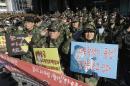 South Korean war veterans salute during a rally against North Korea in Seoul, South Korea, Saturday, Jan. 9, 2016. North Korea trumpets a hydrogen bomb test. South Korea responds by cranking up blasts of harsh propaganda from giant green speakers aimed across the world's most dangerous border. The placards read "Anti-North Korea loudspeaker ? Leaflets? Kim Jong Un is smiling! and An eye for an eye, tooth for tooth, Nuclear for nuclear". (AP Photo/Ahn Young-joon)