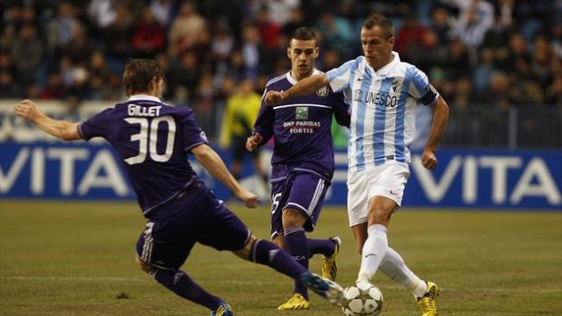 Malaga's Sergio Duda (R) fights for the ball with Anderlecht's Guillaume Gillet (L) during their Champions League Group C soccer match at La Rosaleda stadium in Malaga,