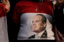 An Egyptian Christian woman wearing a shirt with the photo of Egyptian President Abdel Fattah el-Sissi during a vigil to morn Christians who were killed in Libya, at St. Mark's Cathedral in Cairo, Egypt, Tuesday, Feb. 17, 2015. Egypt is making an ambitious bid to place itself at the center of the fight against extremism across the Middle East. Beyond fighting militants in its own Sinai Peninsula, it is trying to organize an international coalition against the Islamic State in Libya and helping Saudi Arabia defend its borders. (AP Photo/Amr Nabil)