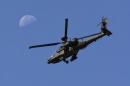 A U.S. Army Apache flies past the moon in the Zharay district of Kandahar province
