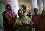 A woman grieves for her late relative after his body was pulled from the rubble in the collapsed garment factory building and brought to the morgue, in Savar, near Dhaka, Bangladesh, Saturday, May 4, 2013. In the aftermath of a building collapse that killed more than 530 people, Bangladesh's garment manufacturers may face a choice of reform or perish. (AP Photo/Wong Maye-E)