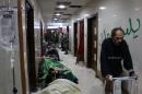 Syrian wounded people lie on the floor at the last functioning hospital as people wait to be evacuated on December 18, 2016 in the last rebel-held pocket of Syria's Aleppo