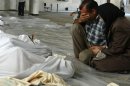 A Syrian couple mourn in front of bodies after what rebels said was a toxic gas attack in Ghouta on August 21, 2013