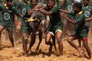 Men try to tame a bull at the "Jallikattu" festival in Palamedu, near Madurai on January 16, 2012