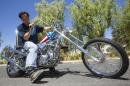 In this Thursday, Sept. 4, 2014 photo, Michael Eisenberg, sits on the customized Captain America chopper Peter Fonda rode in 