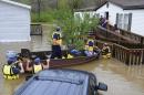 CORRECTS DATE TO APRIL 7 Firefighters rescue a family from their home, surrounded by floodwaters, in a mobile home park in Pelham, Ala., on Monday, April 7, 2014. Overnight storms dumped torrential rains in central Alabama, causing flooding across a wide area. (AP Photo/Jay Reeves)