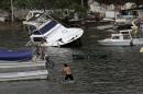 Two men paddle on a small boat towards a yatch that was damaged by winds and rains from hurricane Carlos in the Pacific resort city of Acapulco, Mexico, Sunday, June 14, 2015. Tropical Storm Carlos churned up strong winds and waves Sunday while threatening to regain strength as it trudged up Mexico's Pacific coast. (AP Photo/Bernandino Hernandez)