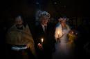 A priest celebrates a marriage under a tent on Independence square in Kiev on February 14, 2014