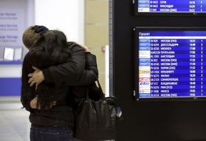 A couple embraces next to a flight information board&nbsp;&hellip;