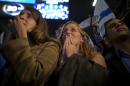 In this Wednesday, March 17, 2015 photo, Zionist Union party supporters react to exit polls at the party's election headquarters in Tel Aviv, Israel. Opinion polls published on the eve of Tuesday's election had shown the center-left Zionist Union slightly ahead of Prime Minister Benjamin Netanyahu's hawkish Likud Party. But as the results trickled in on Wednesday, they showed Likud with a shocking lead that has all but guaranteed Netanyahu a third consecutive term. (AP Photo/Ariel Schalit)