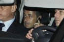 Former French President Sarkozy speaks on the phone as he leaves the courthouse in Bordeaux
