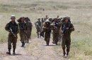 Israeli soldiers walk together during training close to the ceasefire line between Israel and Syria on the Golan Heights